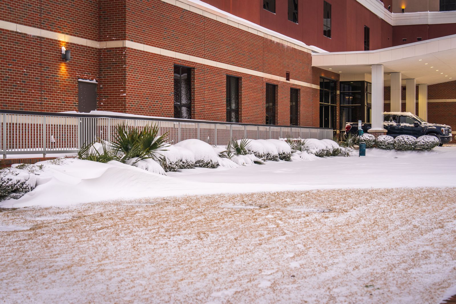 a house covered in snow Brick office building entrance with a canopy after a winter snowfall