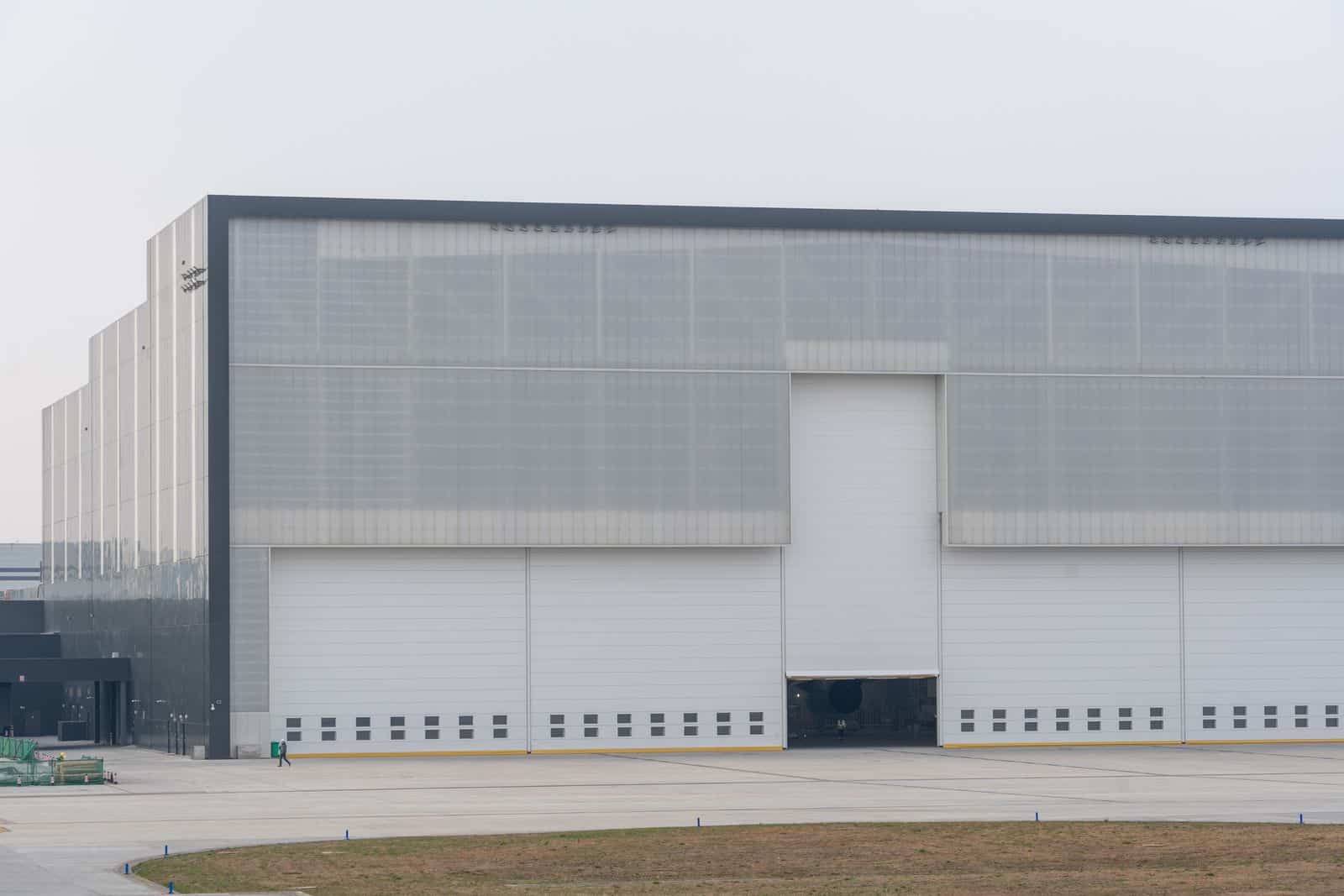 a large building Large modern warehouse exterior with translucent wall panels and roll-up doors