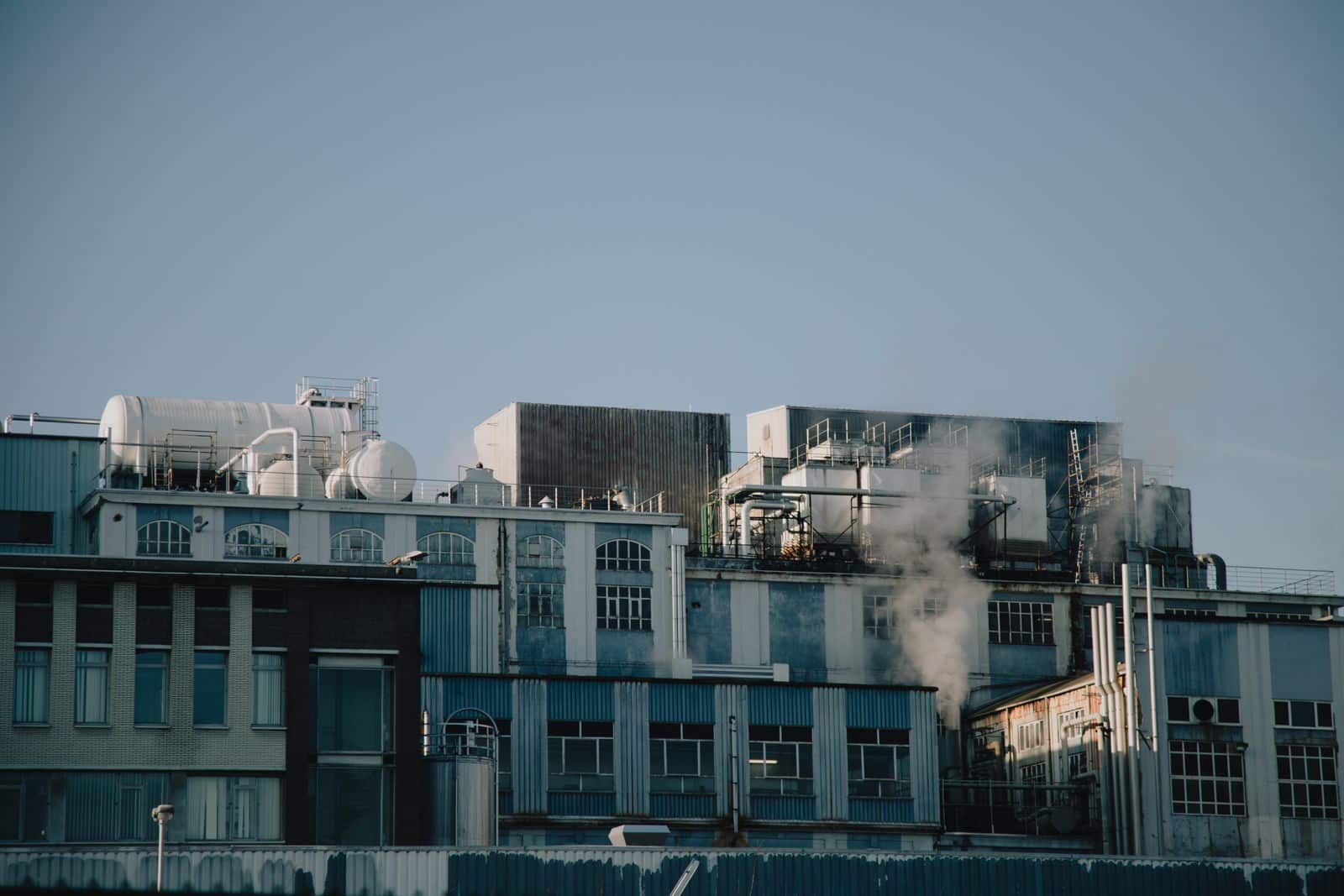 older-industrial-plant-with-rooftop-tanks-ductwork-and Older industrial plant with rooftop tanks, ductwork and mechanical equipment on a low-slope roof