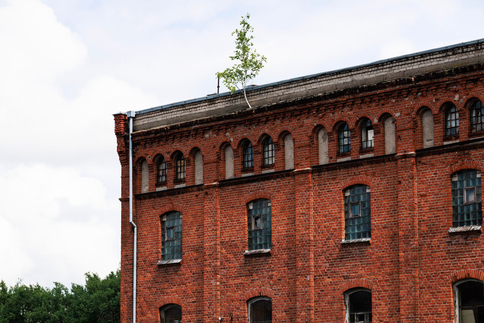 a large brick building with First Missouri State Capitol State Historic Site in the background Red brick industrial building with arched windows and a low-slope roof